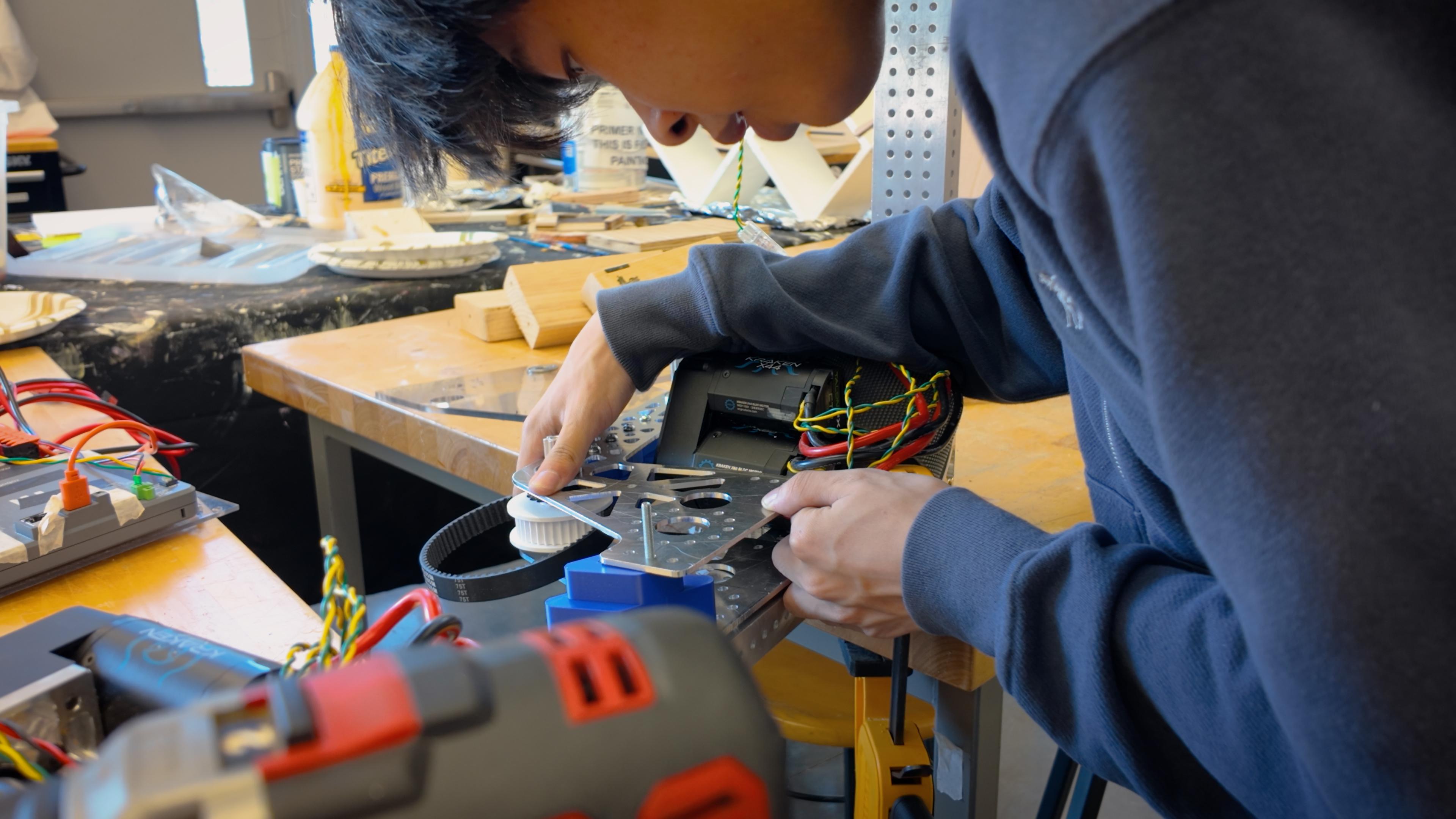 A Rōnin Robotics team member assembling a 2026 robot mechanism.